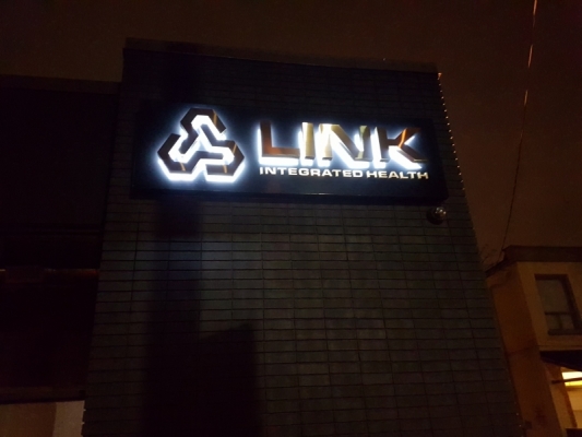 LED illuminated from behind titanium brushed gold letters on black metal box for LINK
