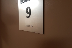 room numbers sign with raised text and braille